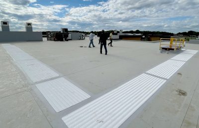 Men walking around a roof with Thermoplastic Polyolefin (TPO)